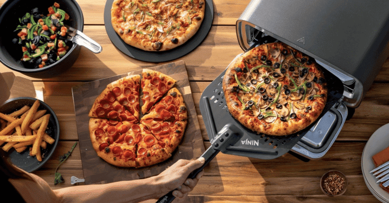 Cuisson de pizza dans un four Ninja artisan sur une table en bois, accompagnée de frites maison et d'une salade fraîche.