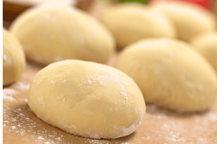 plusieurs pâton de pate disposer cote a cote sur un plan de travail