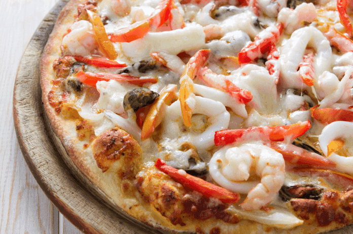 Découvrez une pizza au fruits de mer blanche généreuse aux calamars, moules et crevettes, nappée de crème fondante. Une recette artisanale sans sauce tomate, à tester au four à bois.