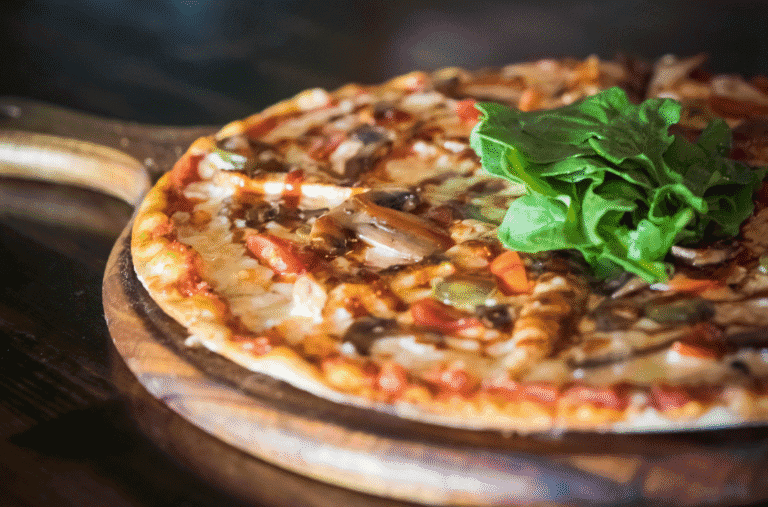 Pizza sur pâte à pizza fine, roquette ajoutée après cuisson, base croustillante et légère.