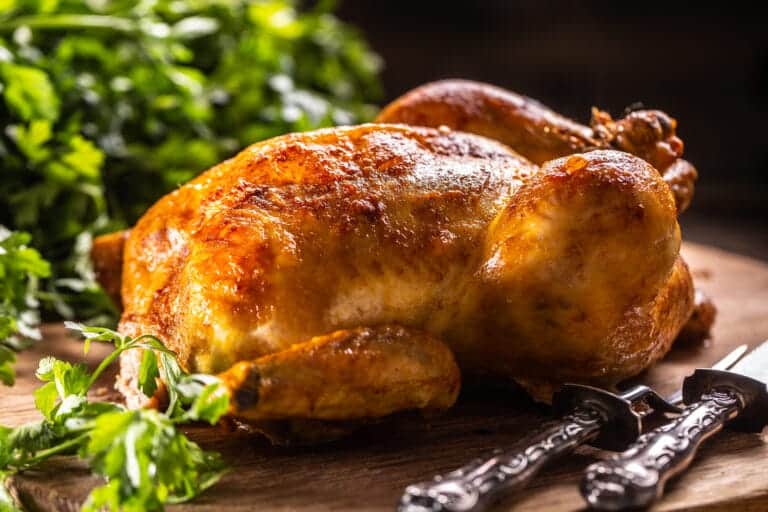 Poulet doré croustillant sur planche en bois avec persil frais