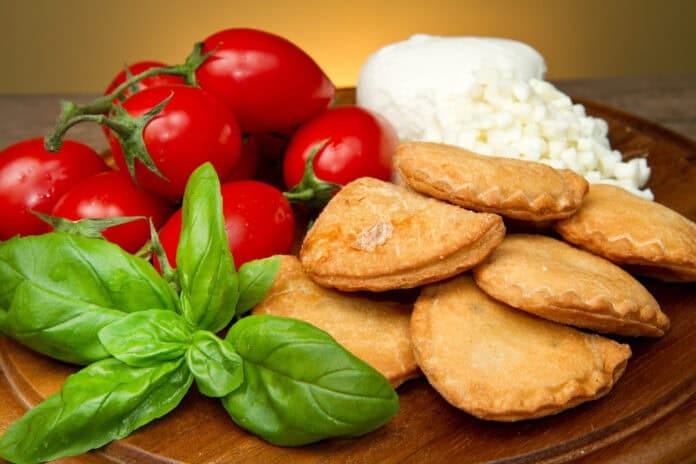 Petits chaussons italiens frits servis avec tomates cerises, basilic et mozzarella hachée